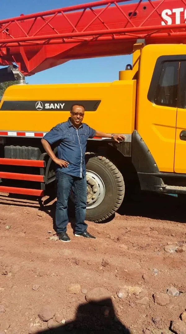 Engineer Kedir Ibrahim beside a SANY 25-ton truck crane supplied to a contractor