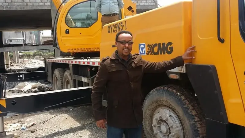 Engineer Kedir Ibrahim beside an XCMG mobile crane at a construction project