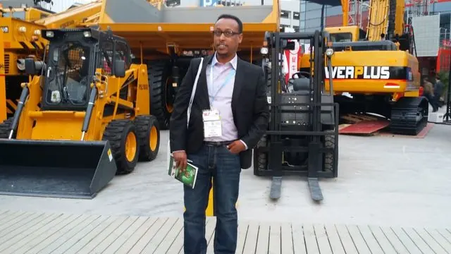 Engineer Kedir Ibrahim among construction machinery at the Bauma International Exhibition